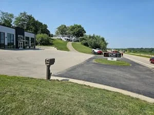 Newly paved asphalt driveway with curved design and mailbox installation