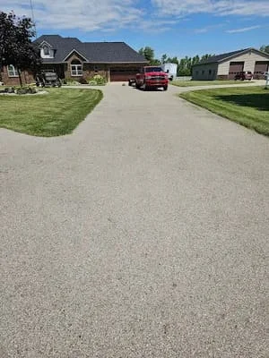 New asphalt driveway with dark aggregate surface and clean edges at residential home