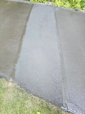 Newly sealcoated asphalt driveway with dark finish and clean edges