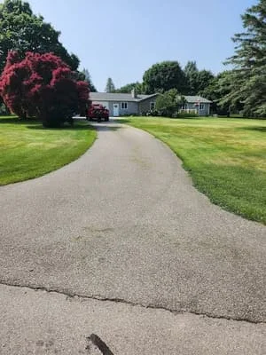 Sealed asphalt driveway with dark finish and curved design leading to residential home